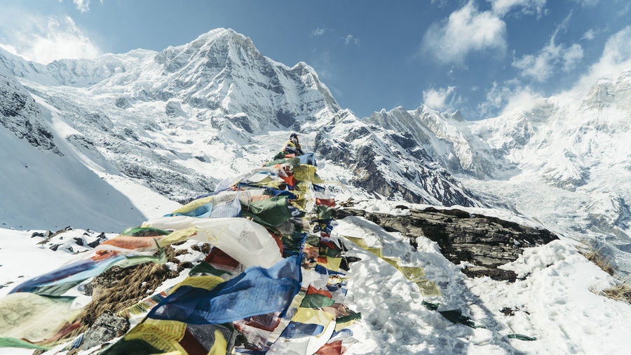 Prayer flags on machapuchare snowcapped mountains against sky