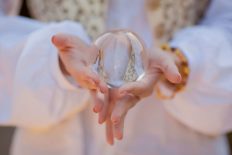 Midsection of woman holding crystal ball