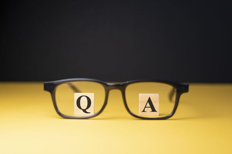 Close-up of yellow eyeglasses against black background