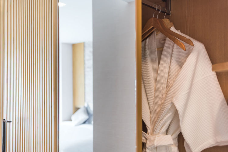 Close-up of clothes hanging in wardrobe at home