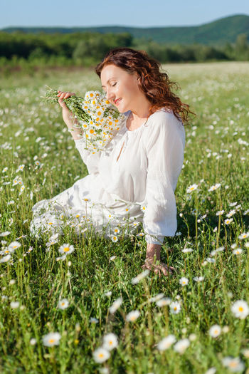 Portrait of young woman sitting on field