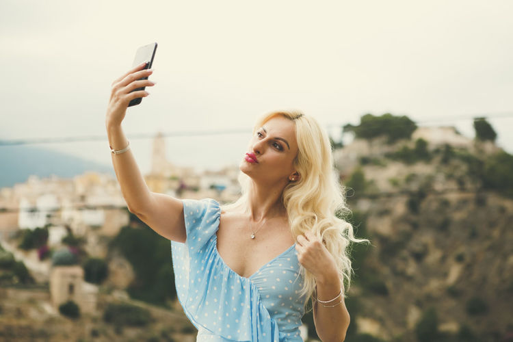 Pretty blonde woman in her 40s taking selfies