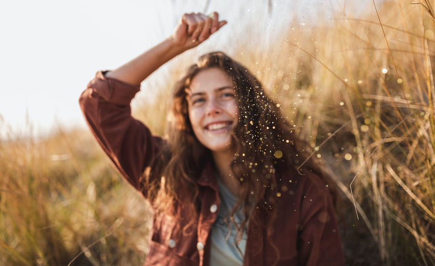 Smiling young woman holding glitter