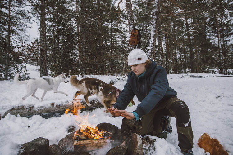 Man sitting near log fire at winter