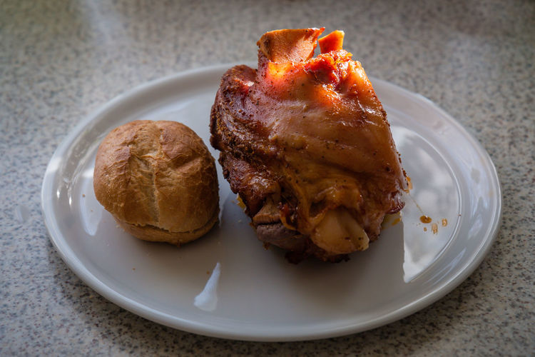High angle view of fried chicken with bread in plate on marble