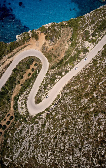 Aerial view of winding road by sea