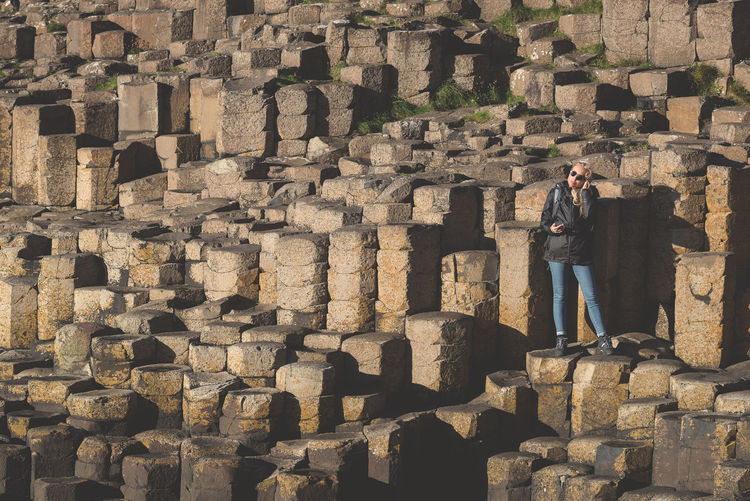 Full length of woman standing on giants causeway