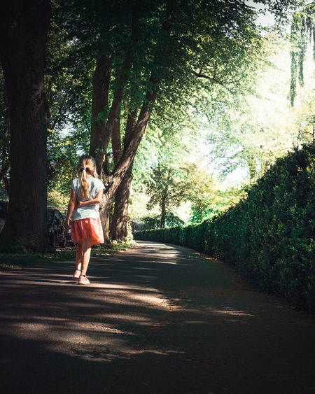 Full length of woman on road amidst trees