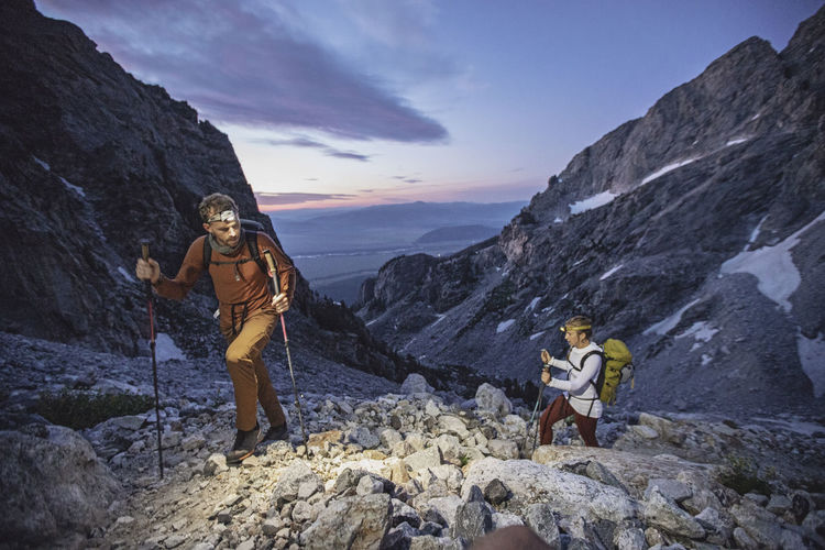 Two hikers climb through the dawn in the teton backcountry, wyoming