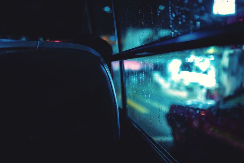 Close-up of wet bus window at night