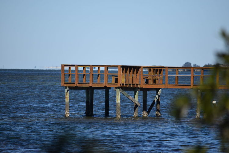 Scenic view of jetty with calm sea against blue sky