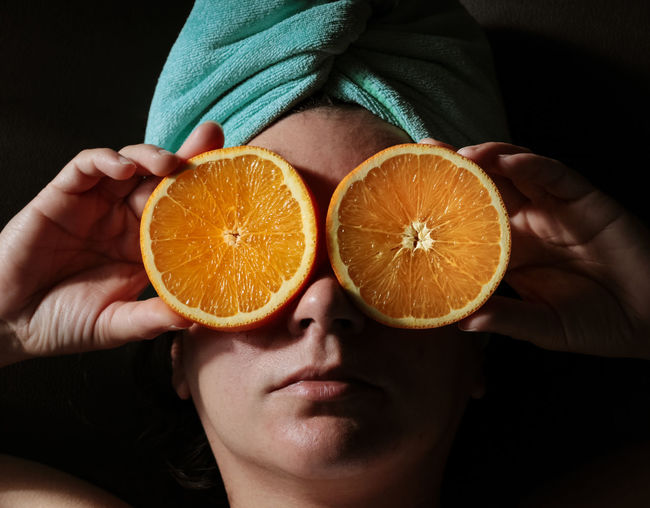 Close-up of woman holding orange slices 