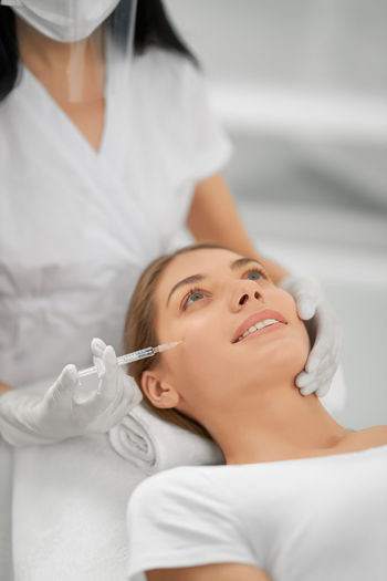 Portrait of woman doing face treatment at clinic