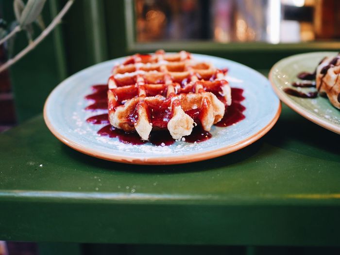 Close-up of served waffle with jam in plate