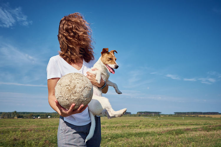 Woman have fun with her dog in summer day outdoors. friendship owner with pet