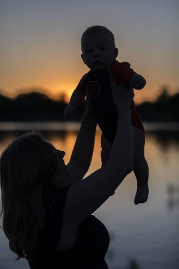 Boy with toy against sky during sunset