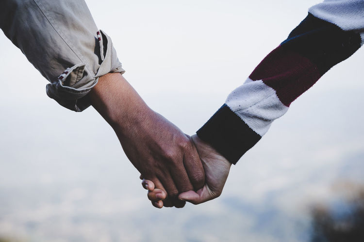 Close-up of couple holding hands outdoors
