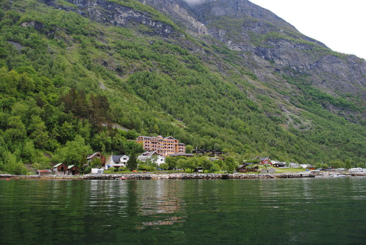Scenic view of lake by buildings against mountain