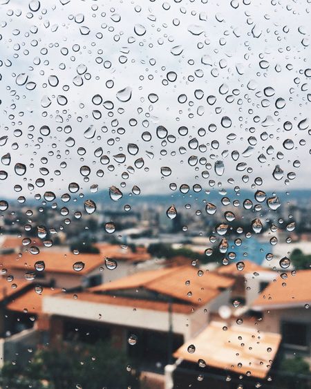Close-up of waterdrops on glass against blurred background