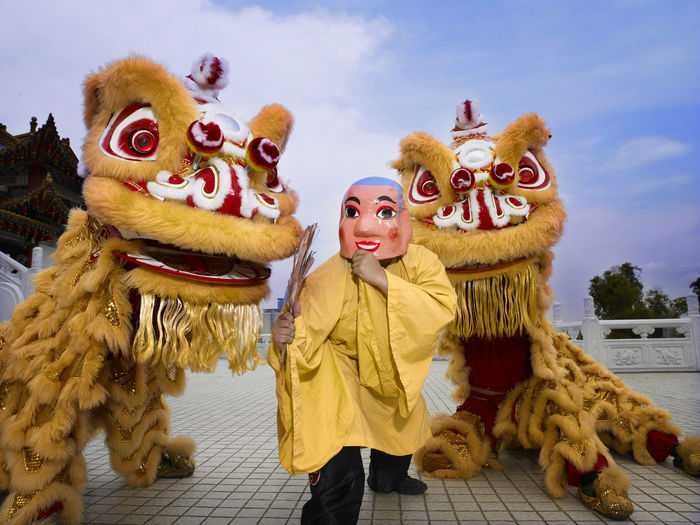 Two yellow lion dance and big head buddha at temple