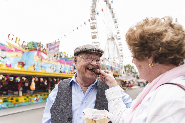Portrait of happy senior man having fun with his wife on fair