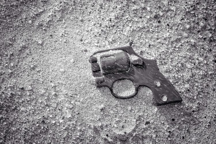 High angle view of broken gun on sand
