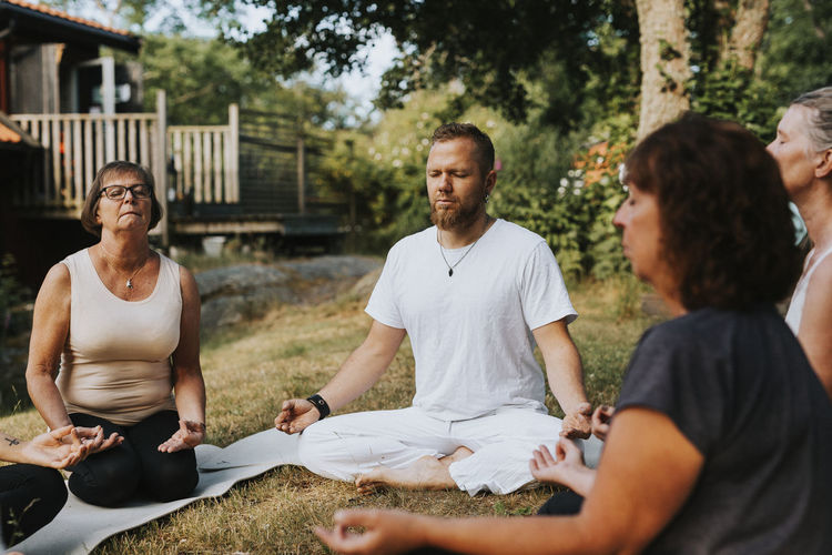 People meditating in garden