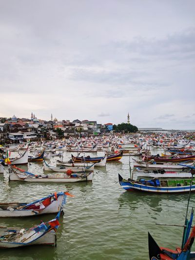Boats moored in river against buildings in city