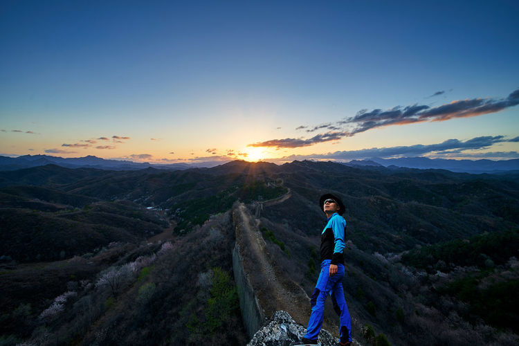 Man at great wall of china against sky during sunrise