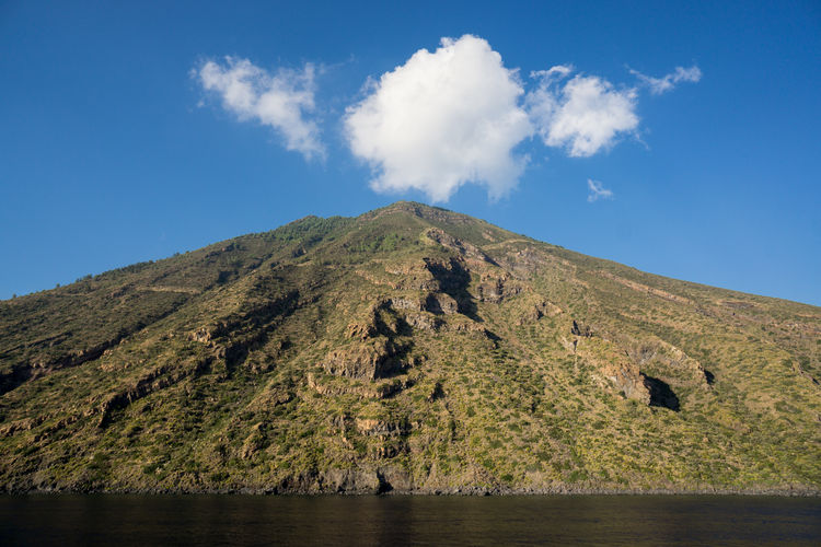 Low angle view of volcano by sea at stromboli