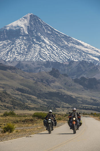 Couple on touring motorbikes. lanin volcano in the back, argentina