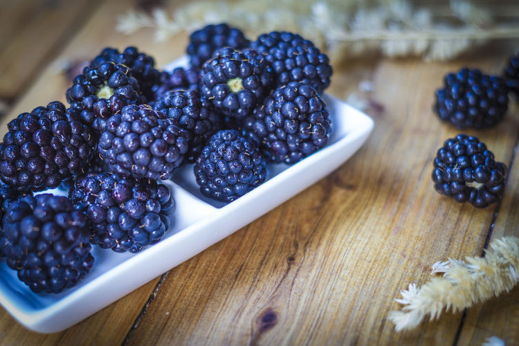 High angle view of blackberries in plate on table