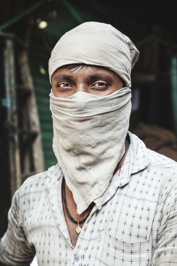 Portrait of man with face covered by handkerchief