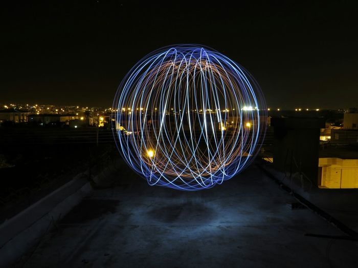 Light painting on building terrace against sky at night