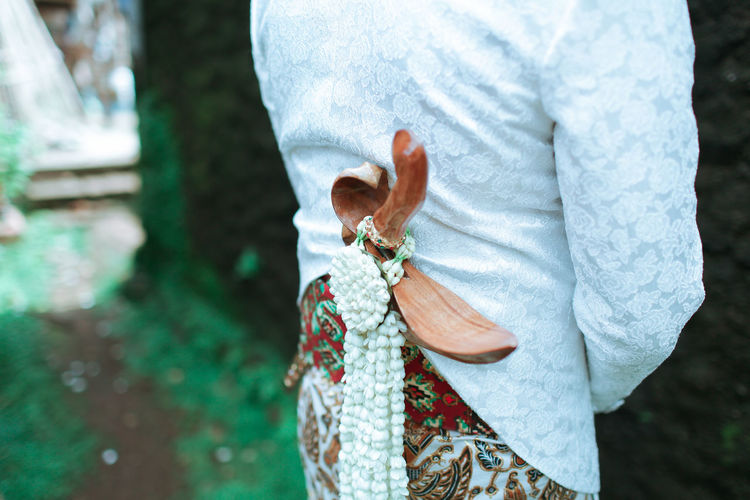 Midsection of bridegroom with dagger during wedding ceremony