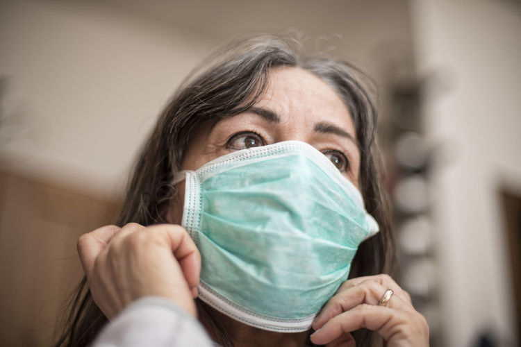 Woman looking away while wearing surgical mask