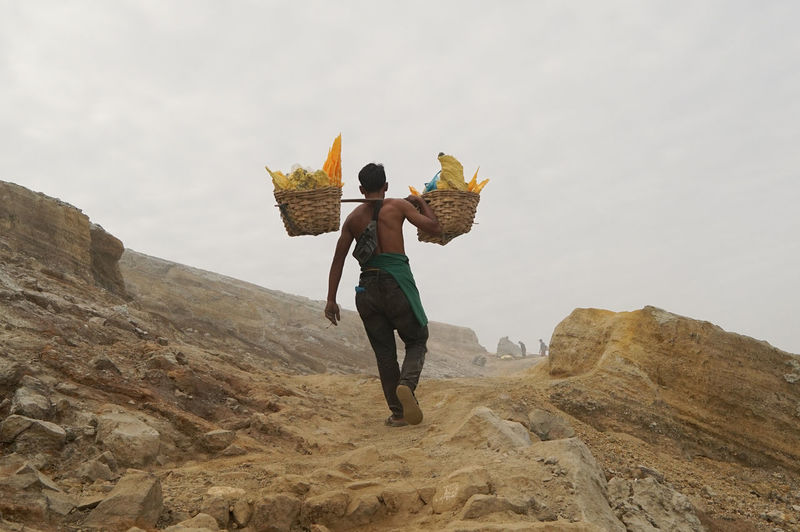 Sulphur miners activity at mount ijen in banyuwangi, indonesia.