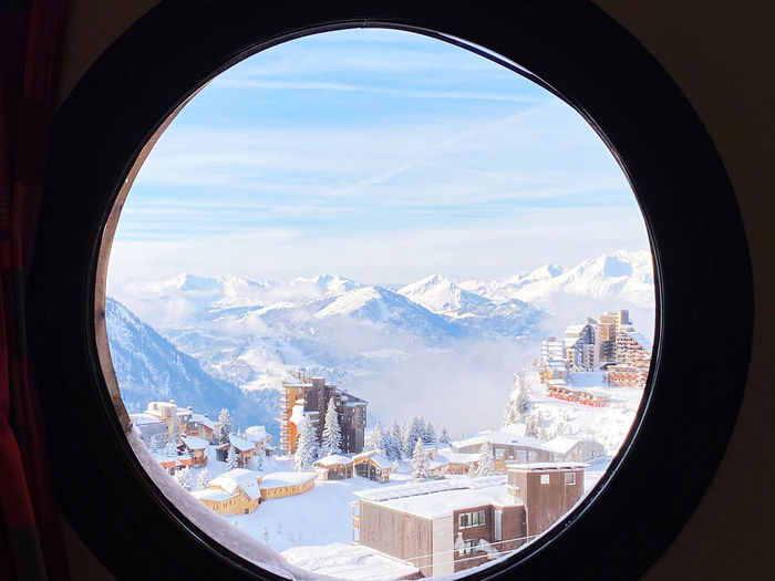 Scenic view of mountains seen through window during winter