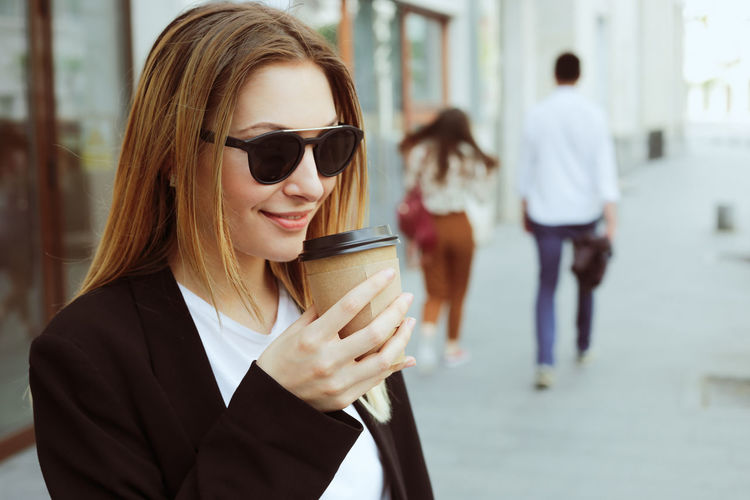 Young woman wearing sunglasses while standing outdoors