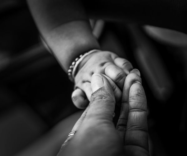 Close-up of woman holding baby hand