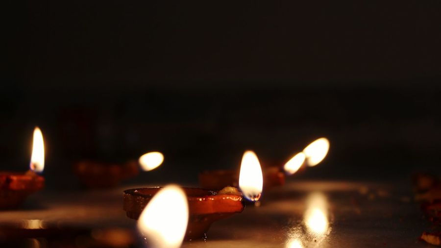 Close-up of lit candles on retaining wall at night