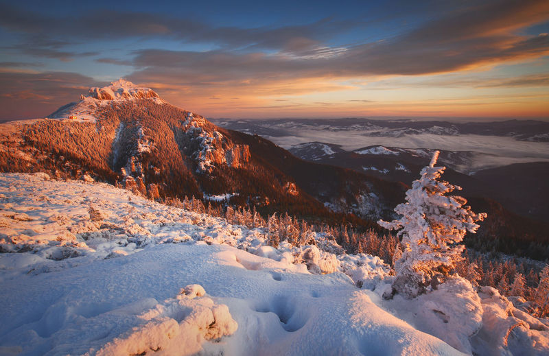 Scenic view of snow mountains against sky during sunset