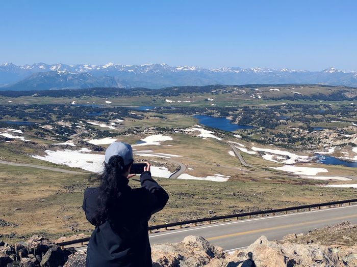Man photographing on mountain against sky