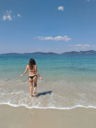 Full length of woman on beach against sky