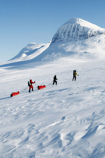 Tourists cross country skiing against mountain scenery