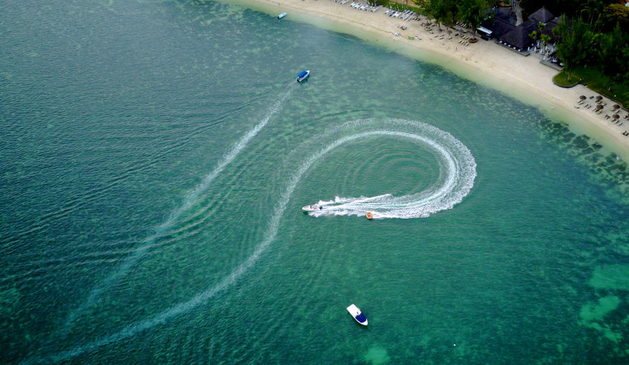 Aerial view of motorboat forming water wake ion sea