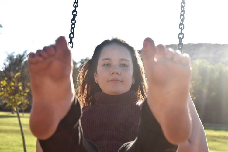 Portrait of girl on swing in playground