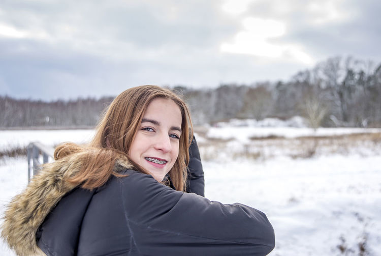 Portrait of smiling girl on snow covered land