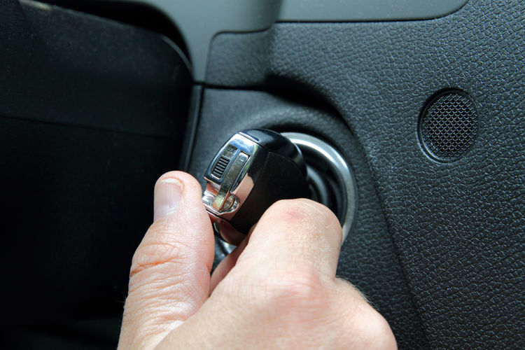 Cropped hand touching key in car