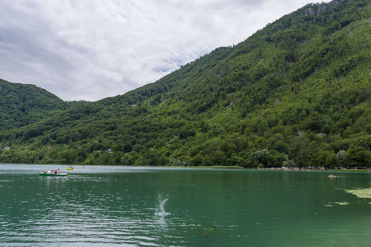 Scenic view of lake by mountains against sky